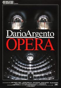 Argento’s Opera stands out as one of his most distinct films, tempered with modernity versus fantasy in a vibrant clash with insanity. Michele Soavi, director of Cemetery Man mentored under Argento and plays the Inspector, costarring with a notoriously difficult to work with conspiracy of ravens, delivering an impressively accurate performance